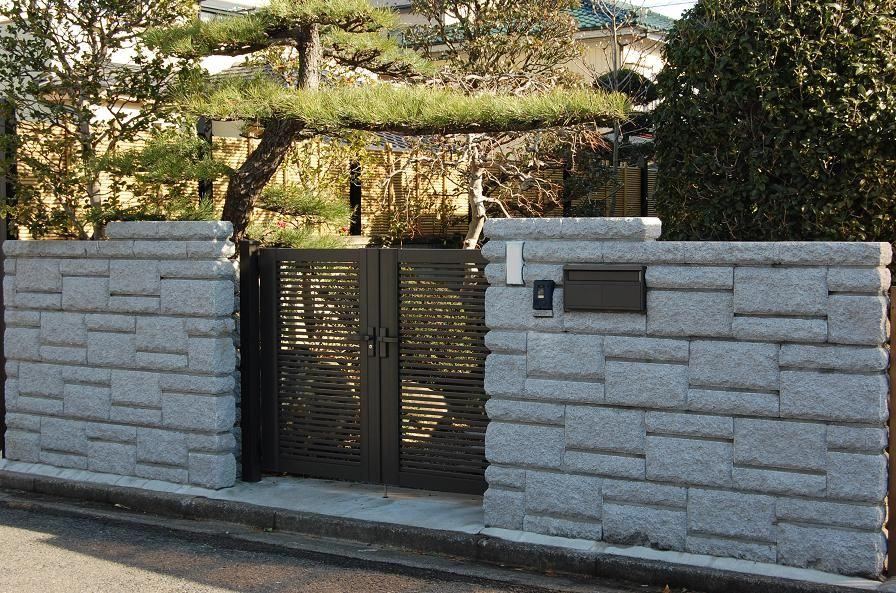 石調ブロック塀と黒い門扉を設けた玄関まわりの外構