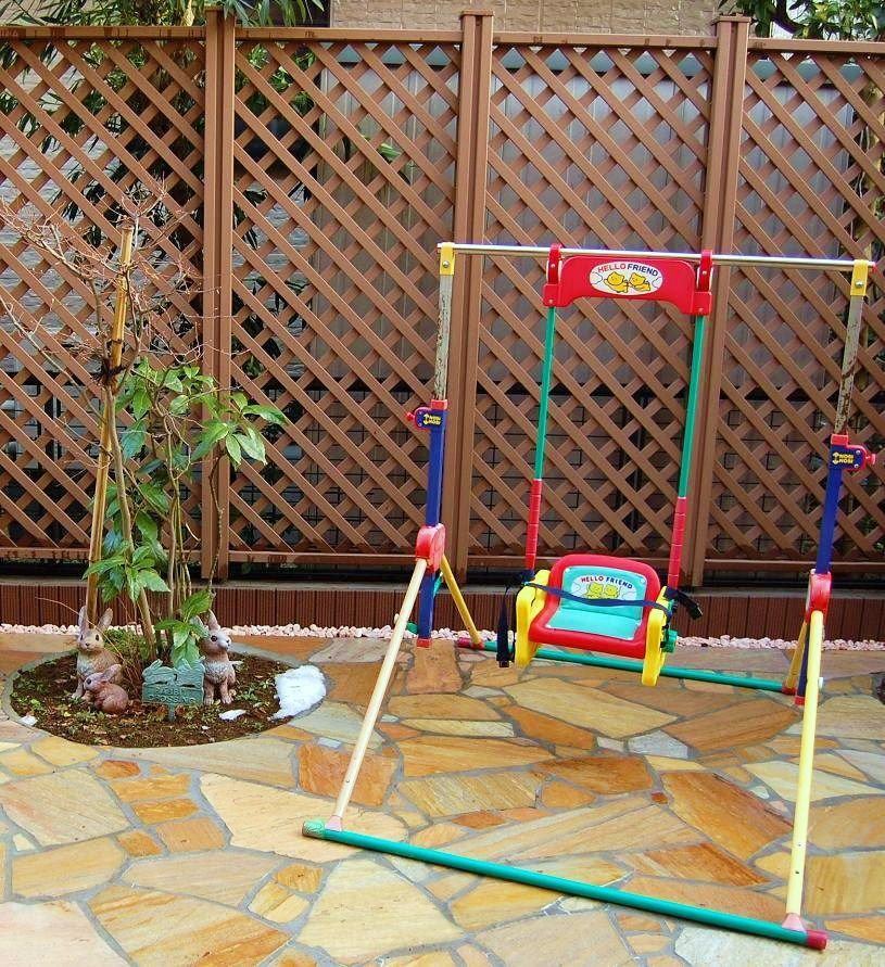 石張りの庭に置かれた子ども用のブランコ