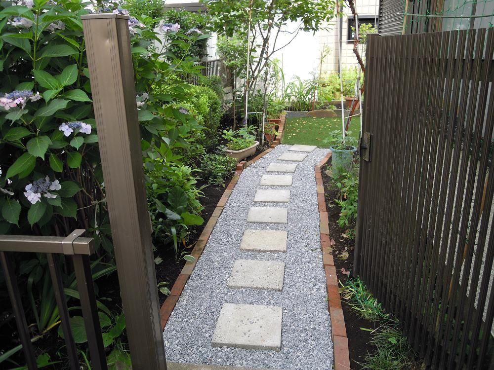 平板の通路と砂利、木製フェンスと紫陽花